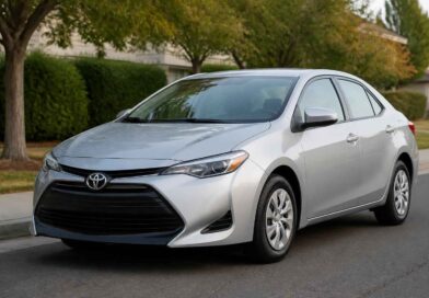Srebrna Toyota Corolla zaparkowana na ulicy w otoczeniu drzew i zieleni miejskiej